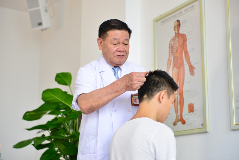 国医大师黄瑾明为患者进行壮医药线点灸疗法治疗。beat365中文官方网站供图